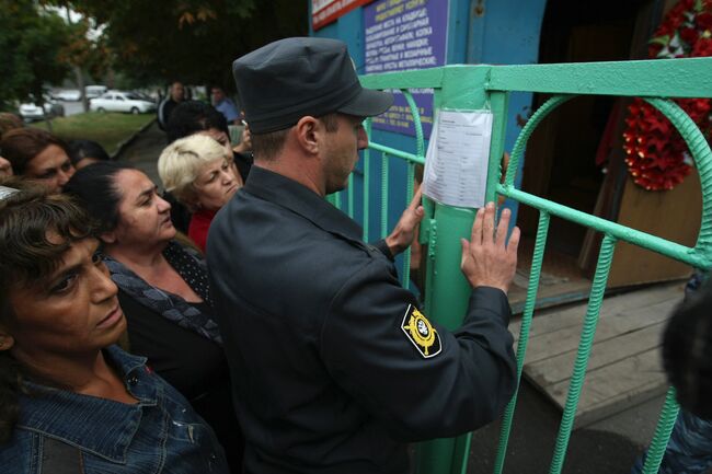 Родственники пострадавших от взрыва во Владикавказе у здания городского морга, где вывешены списки погибших в результате теракта