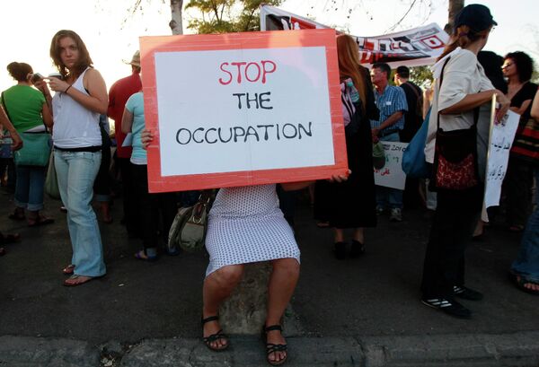 Израильские активисты протестуют в знак солидарности с палестинцами против израильских поселений
