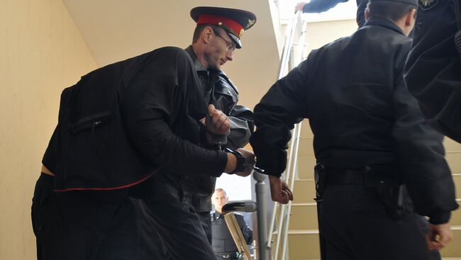 Сотрудники милиции ведут одного из главных подозреваемых в деле об убийстве 12 человек в станице Кущевская, архивное фото