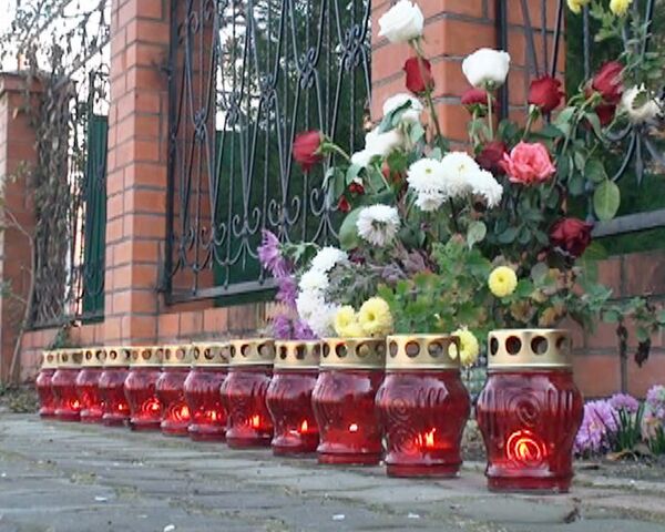 К дому, где убиты 12 человек, приносят живые цветы и ставят свечи 