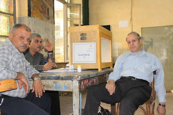 Сотрудники районной избирательной комиссии в центре Каира в ожидании избирателей
