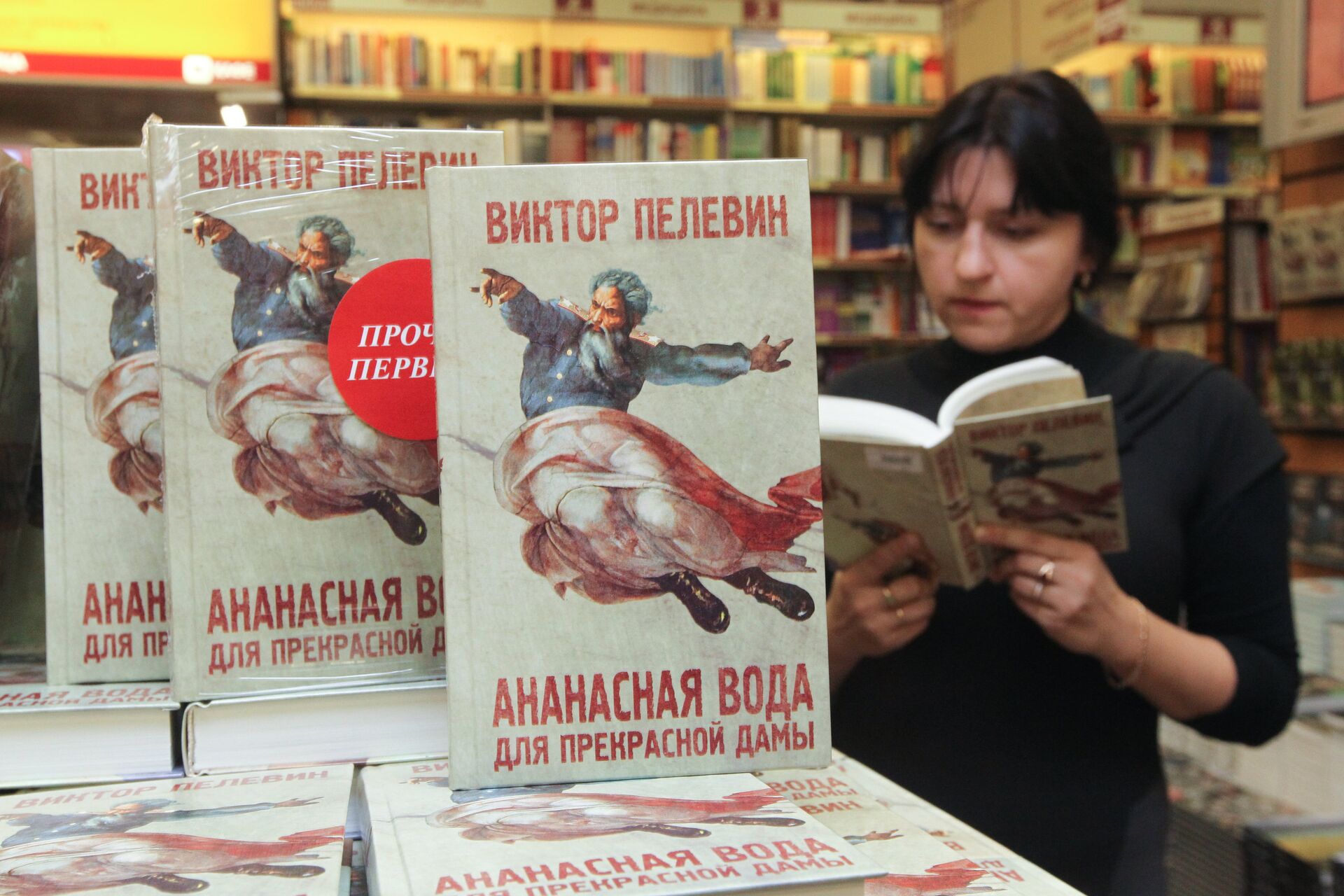 Женщина читает новую книгу Виктора Пелевина Ананасная вода для прекрасной дамы в торговом доме Библио-Глобус - РИА Новости, 1920, 21.11.2022