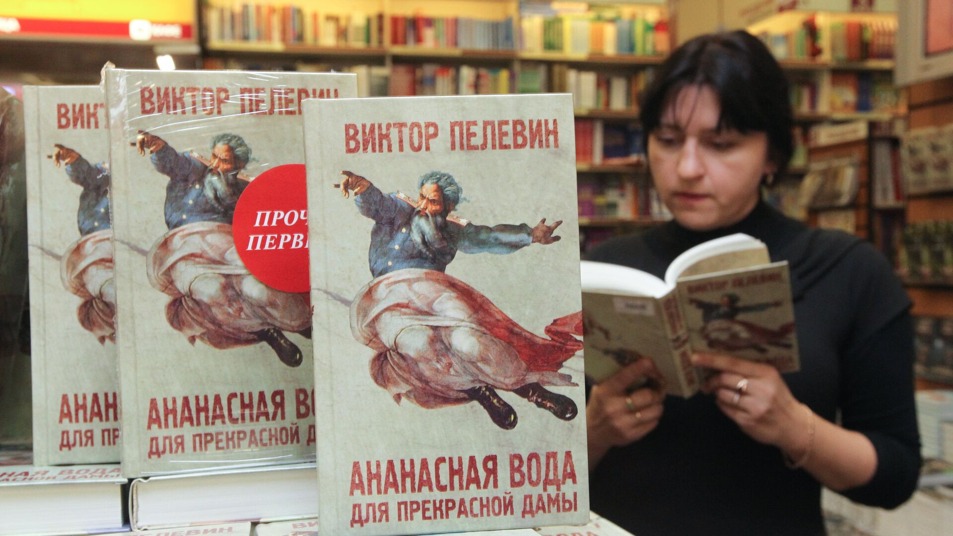 Женщина читает новую книгу Виктора Пелевина Ананасная вода для прекрасной дамы в торговом доме Библио-Глобус - РИА Новости, 1920, 22.11.2022