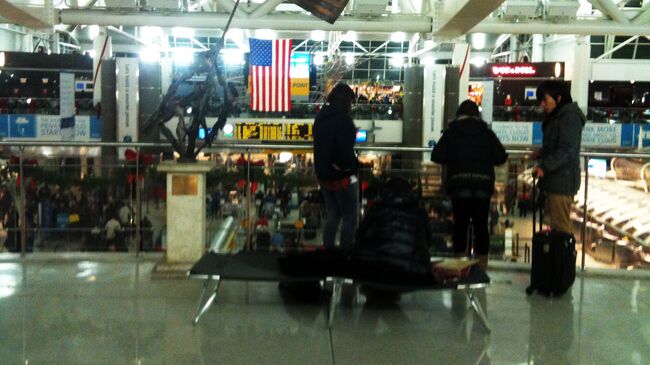 Пассажиры в аэропорту имени Джона Кеннеди в Нью-Йорке