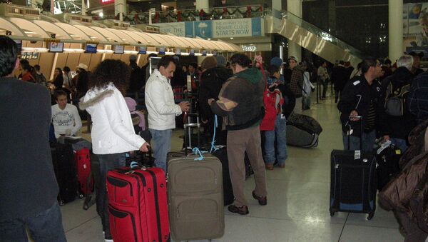 Пассажиры в аэропорту имени Джона Кеннеди в Нью-Йорке