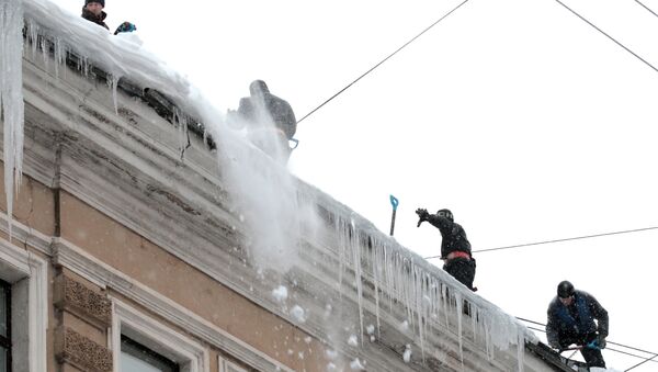 Сотрудники коммунальных служб очищают крыши домов в Санкт-Петербурге от сосулек. Архив