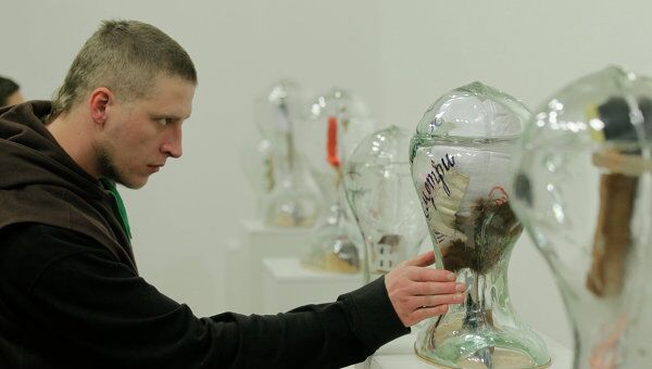 Посетитель осматривает скульптуру Смотри вверх на выставке Виктора Пивоварова ОНИ