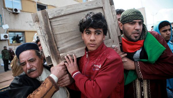 Жители Бенгази во время демонстрации против режима Каддафи несут гроб с телом убитого ливийца