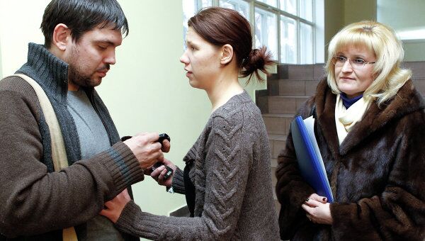 Задержанный по подозрению в грабеже сотрудник телеканала НТВ Павел Ермолов, его невеста Анастасия Кулагина и адвокат Ольга Михайлова (слева направо).