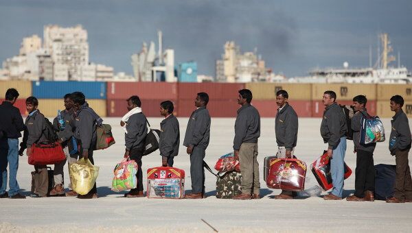Иностранные рабочие - беженцы c вещами в порту Бенгази ожидают корабль в надежде покинуть Ливию.