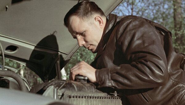 Гагарин занимается ремонтом автомашины. Архив