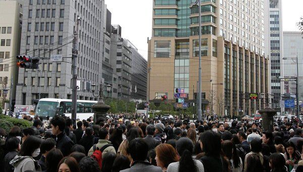 Люди эвакуированные из зданий в финансовом районе Токио после землетрясения 11 марта 2011