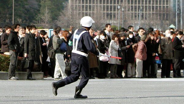 Люди эвакуированные из зданий в финансовом районе Токио после землетрясения 11 марта 2011