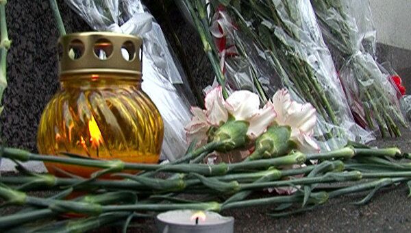 Люди несут живые цветы и свечи к посольству Японии в Москве