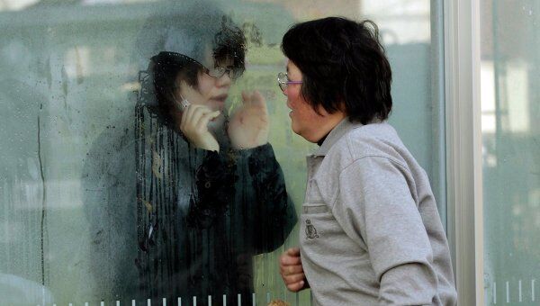 Японская девушка, которая получила повышенную дозу, общается через свинцовое стекло со своими родственниками 