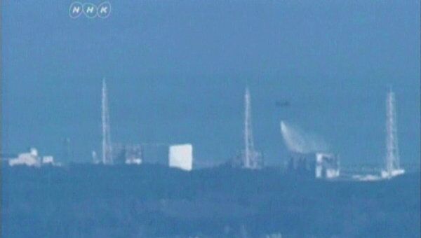Вертолет сил внутренней безопасности Японии сбрасывает воду на аварийную японскую АЭС Фукусима-1, 17 марта 2011