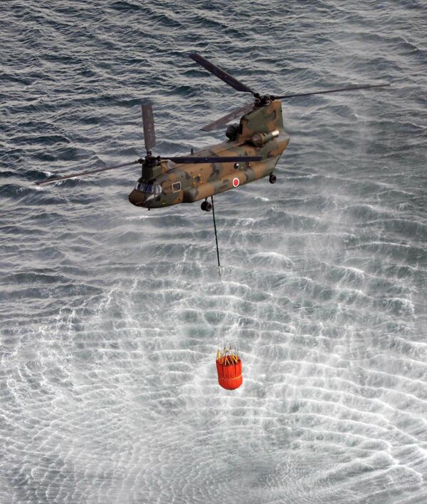 Вертолет набирает воду для устранения последствий аварии на АЭС Фукусима