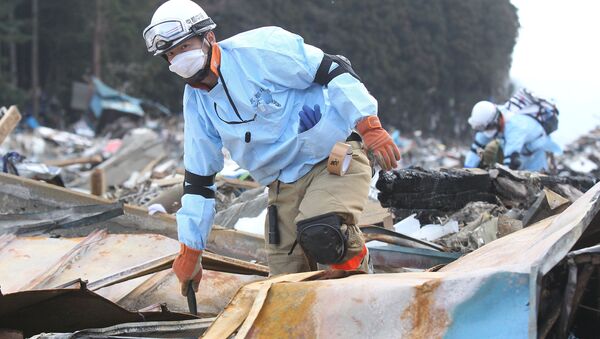 Спасатели в разрушенном от землетрясения городе Минами-Сенрику