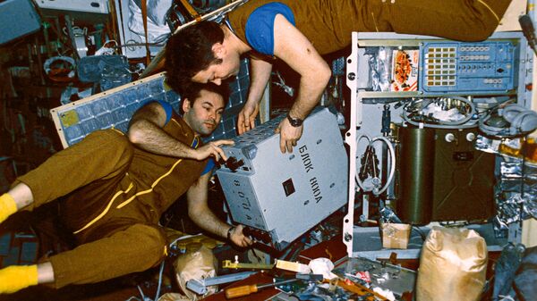 Юрий Романенко и Александр Лавейкин проводят монтаж блока элекстропитания на борту орбитальной станции Мир