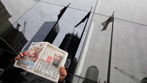 Мужчина читает газету с заголовком о ликвидации Усамы бен Ладена в центре Нью-Йорка