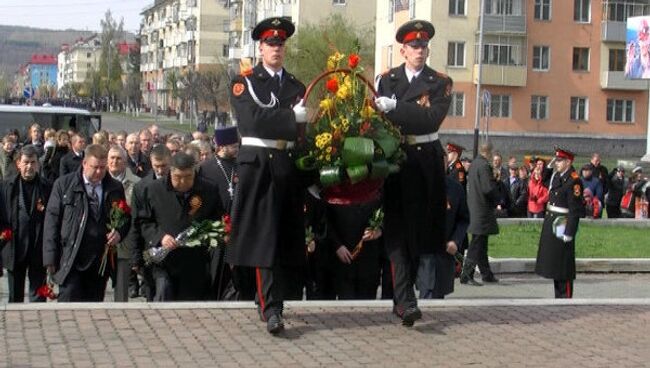 Люди несут цветы на могилы погибших горняков Распадской