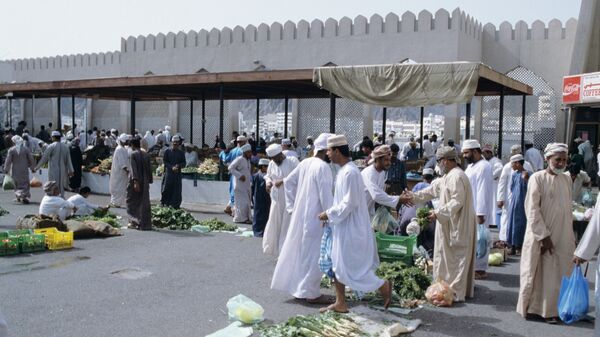 Торговцы и покупатели на рынке Омана