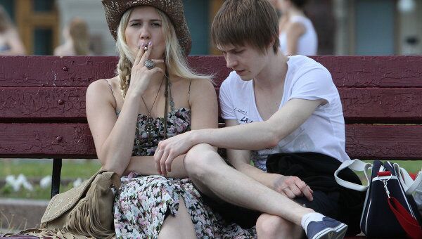 Молодые люди курят на одной из улиц Москвы
