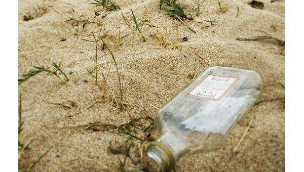 Пустая бутылка из-под алкоголя на пляже