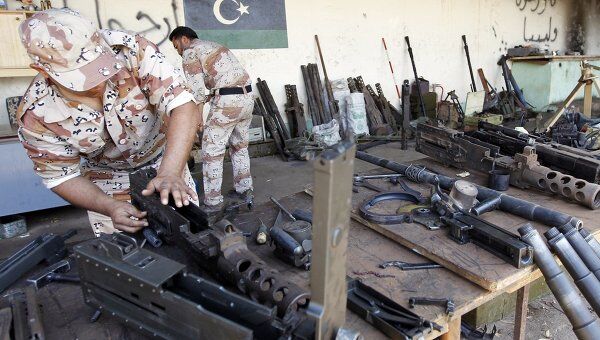 Ливийский повстанец разбирает оружие 