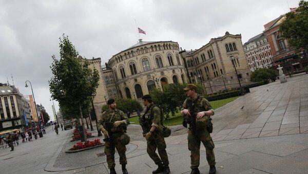 Здание парламента Норвегии с приспущенным флагом охраняется солдатами