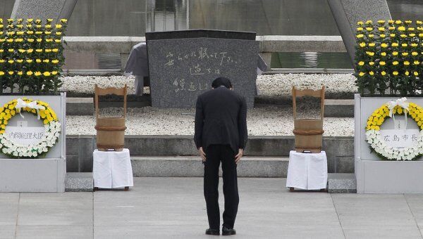 Премьер-министр Японии Наото Кан у памятника жертвам