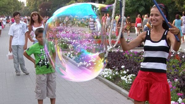 Девушка запускает большие мыльные пузыри на Приморском бульв