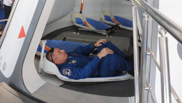 Сотрудник Роскосмоса демонстрирует пилотируемый космический корабль Русь на Десятом международном авиакосмическом салоне МАКС-2011.