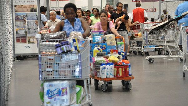 Нью-йоркцы выходят из магазина с полными корзинами в ожидании урагана Айрин