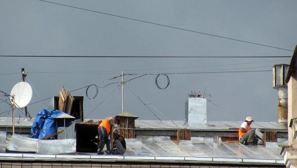 Московские рабочие перекрывают крышу многоэтажки без страховки