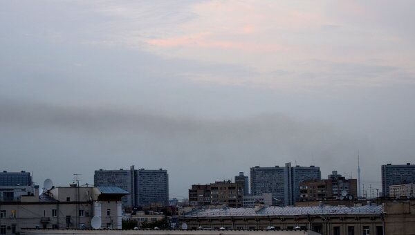 Дым от крупного возгорания травы на пустыре на севере Москвы