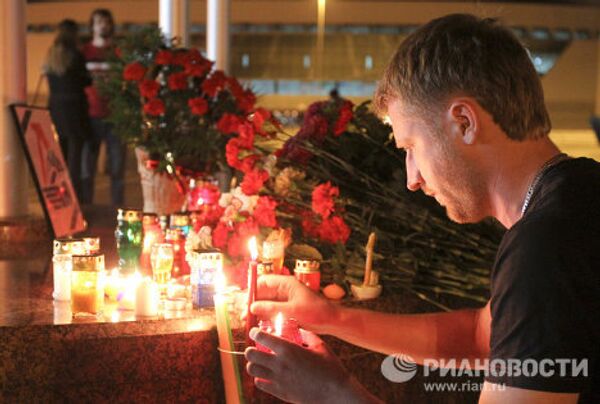 Жители Минска несут цветы и зажженные свечи к Минск-Арене