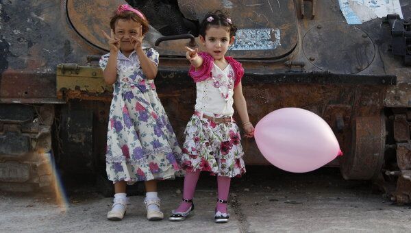 Ливийские дети играют на фоне сгоревших танков Муамара Каддафи