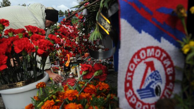 Цветы и свечи в память о погибших хоккеистах ярославского Локомотива у стадиона Арена-2000