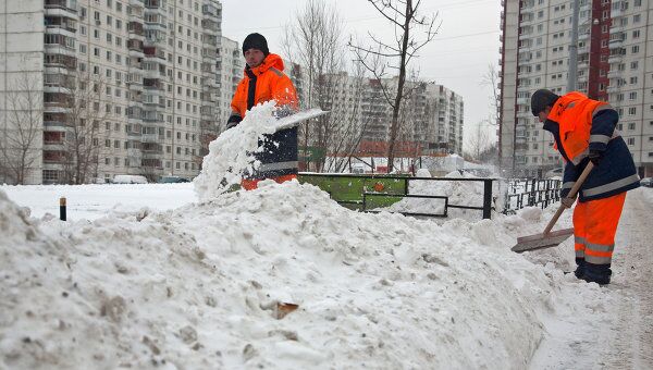 Дворники расчищают снег на одной из улиц Москвы