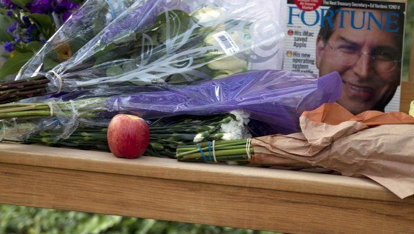 Люди несут цветы к штаб-квартире компании Apple в память о Стиве Джобсе