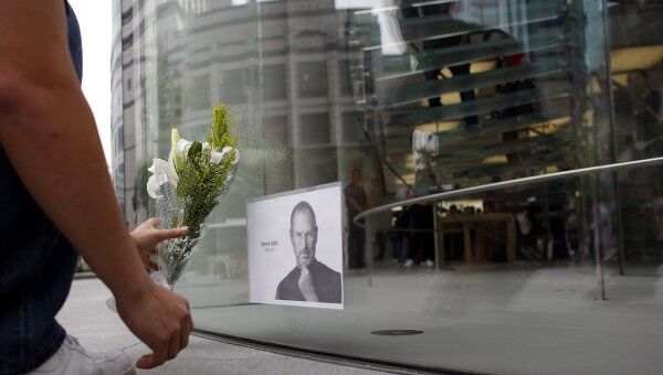 Люди несут цветы к магазину Apple в память о Стиве Джобсе