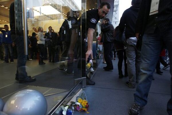 Люди приносят цветы и свечи к магазину Apple Store в Сан-Франциско