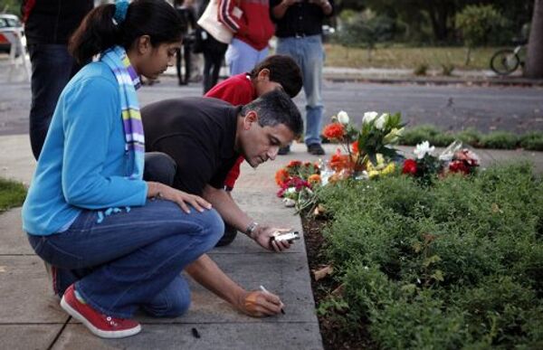 Люди приносят цветы и свечи к дому Стива Джобса в Калифорнии 