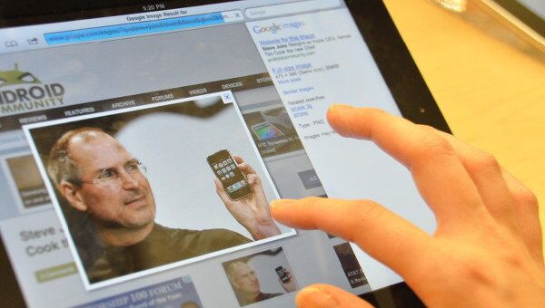 Изображение Стива Джобса на экране планшета, архивное фото