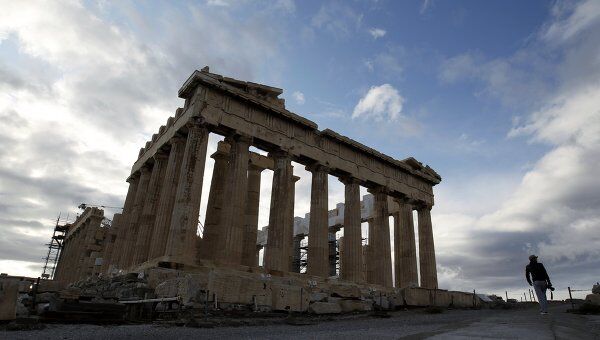 Турист проходит мимо здания Акрополя в Афинах 
