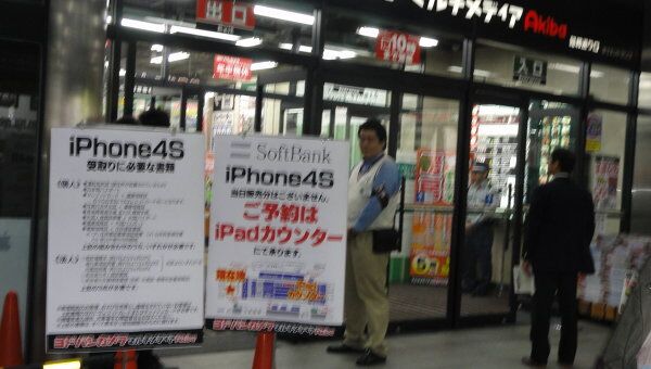 Плакаты перед магазином электроникиd в Токио, возвещающие о начале продаж iPhone 4S