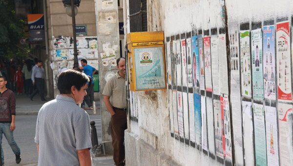Жительница Туниса изучает списки кандидатов на выборах в Национальный учредительный совет