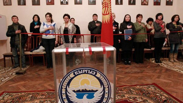 Наблюдатели у урны для голосования слушают государственный гимн Киргизии после закрытия избирательных участков в Бишкеке