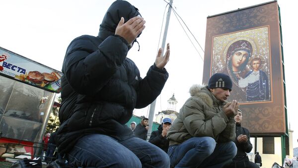 Мусульманет совершают намаз на улице в Москве.